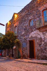 a stone building with a palm tree in front of it at Hotel Boutique Morada De Paz in Real de Catorce