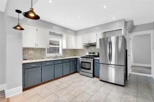 a kitchen with blue cabinets and a stainless steel refrigerator at Black door bungalow in Windsor