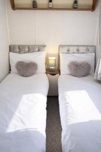 a room with two beds with pillows on them at Rosie's Seton Retreat in Port Seton