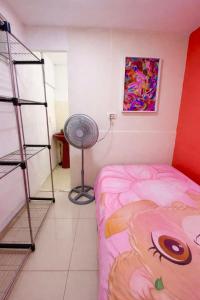 a bedroom with a pink bed and a fan at Tico-living in Alajuela