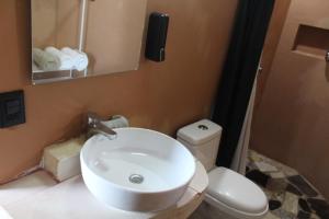 a bathroom with a white sink and a toilet at Hotel Kocai Izamal in Izamal +25 photos
