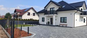 a white house with a bench in a driveway at Wakacyjna Pokusa in Kroczyce
