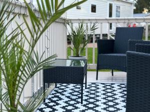 a patio with two chairs and a glass table at Rosie's Seton Retreat in Port Seton +20 photos
