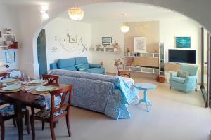 a living room with a blue couch and a table at Panorama e Relax Lago Maggiore - piscina, tennis in Germignaga