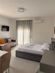 a bedroom with a large bed and a couch at Marina Oasis Apartments in Vlorë