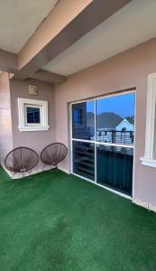 a balcony with two chairs and a large window at Abuja Lux Apartment Wuye in Abuja +8 photos