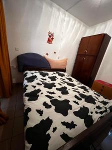 a bedroom with a black and white bedspread with cows at Giada in Iragna