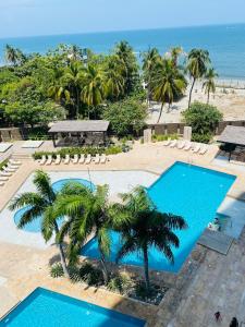 an overhead view of a pool with palm trees and the ocean at Reserva del Mar 539 in Santa Marta
