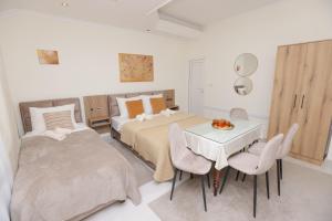 a bedroom with two beds and a table and chairs at Vila Oaza in Bela Crkva