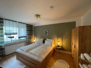a bedroom with a large white bed and a window at Ferienwohnung Stadt-Wald-Park in Bad Harzburg