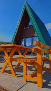 a house with a green roof and a wooden bench at Hot Tub Paradise - Squirrel's House in Žabljak