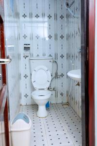 a bathroom with a toilet and a sink at Peak Motel in Kasese
