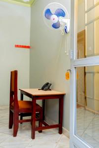 a room with a desk with a phone and a fan at Peak Motel in Kasese +10 photos
