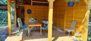 a wooden cabin with a table and chairs on a deck at Szarotka in Brenno