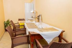 a dining room with a table and some chairs at Peak Motel in Kasese