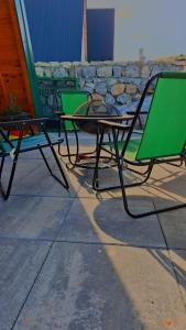 two lawn chairs and a table and two chairs at Hot Tub Paradise - Squirrel's House in Žabljak