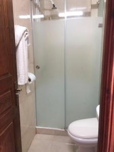 a bathroom with a toilet and a glass shower door at Hotel El Maghreb in Constantine