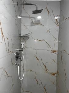 a shower in a bathroom with marble walls at H Veza in Spille +114 photos