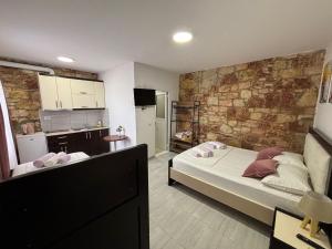 a bedroom with a bed and a brick wall at Grand Seaview Apartments in Ksamil
