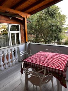 a table and chairs on a porch with a red and white tablecloth at H Veza in Spille