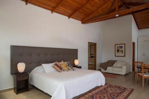 a bedroom with a large white bed and a couch at Ranch Pachacamac in Pachacamac