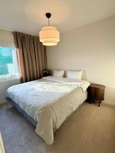 a bedroom with a bed and a large window at Flott 4-roms leilighet til leie in Trondheim