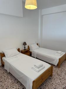 two beds in a room with white sheets at Evdilos Icaria 'Sto Plakostroto' by BRP-Properties in Evdilos