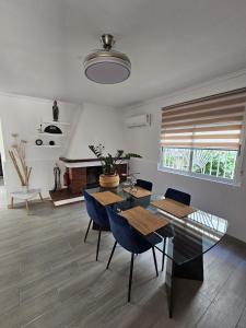 a dining room with a glass table and blue chairs at Casa en La Marina cerca de la Playa y Pinada in Elche
