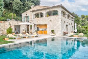 a villa with a swimming pool in front of a house at Ideal BnB, Luxury Apartments in Saint Paul de Vence