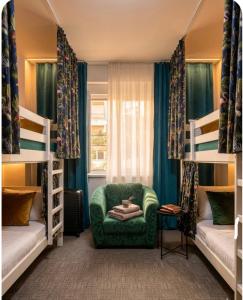 a bedroom with bunk beds and a green chair at Amazon Hostel Center Podgorica in Podgorica
