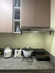 a kitchen counter with two toasters and a toaster at Fullerton suites C homestay in Silang