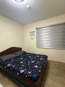 a small bedroom with a bed and a window at Fullerton suites C homestay in Silang