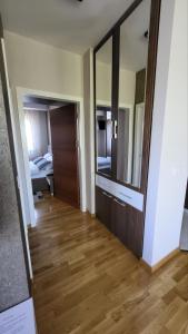 a room with a hallway with a wooden floor and a mirror at SiM Lux in Čačak +22 photos