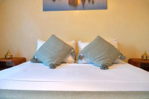 a white bed with two pillows on top of it at Palm View in Marrakesh