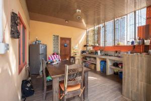 a kitchen with a table and a refrigerator at Avellanas Surf Hostel in Playa Avellana