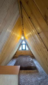 a attic room with a window in a wooden building at Ditaket Dilijan in Dilijan