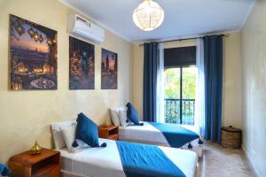 a hotel room with two beds and a window at Palm View in Marrakesh