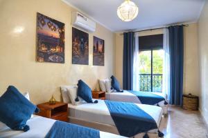 a bedroom with three beds and a window at Palm View in Marrakesh