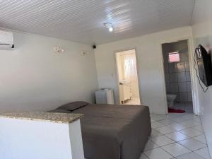 a bedroom with a bed in a room with a bathroom at Repouso Tranquilo in Assis