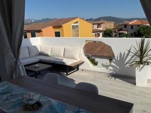 a patio with a couch and a table at Casa vacanza Tanaunella in Budoni