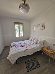 a bedroom with a large bed and a table at Casa en La Marina cerca de la Playa y Pinada in Elche +25 photos