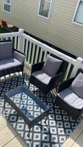 a patio with two chairs and a table on a deck at Crichtons Caravan at Haven Seton Sands in Port Seton