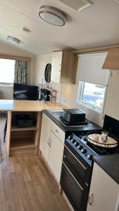 a kitchen with a stove and a counter top at Crichtons Caravan at Haven Seton Sands in Port Seton