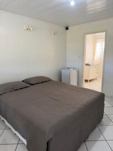a bedroom with a large bed and a refrigerator at Repouso Tranquilo in Assis