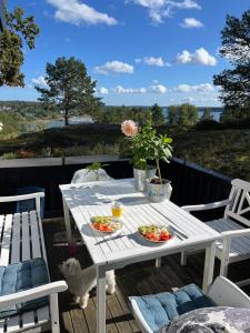 a white table with two plates of food on a deck at Ikigaiisättra 44 in Åkersberga