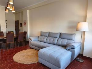 a living room with a blue couch and a table at Apartment by the beach! With large balcony! in São Martinho do Porto +4 photos