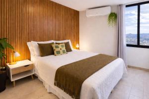 a bedroom with a large bed and a large window at Apartamento con vistas, balcón, gym y parking in Tegucigalpa