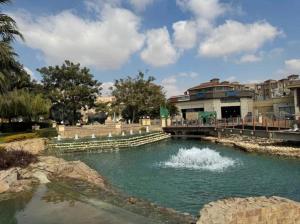 a pool of water with a bridge and buildings at Luxury Smart Home Entire Apartment with 2 Bedrooms in Madinaty in Madinaty