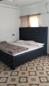 a bed sitting in a bedroom with a window at Modern Way Guesthouse in Kasoa +3 photos