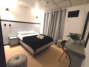 a small bedroom with a bed and a table at Santa lucia in Panama City